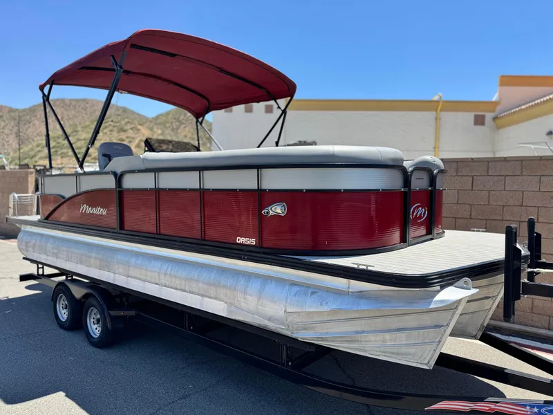 Slide: The Image of 2019 Manitou 23 Oasis pontoon boat with red canopy on a trailer. - 1
