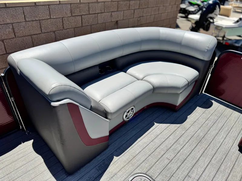 Slide: The Image of 2019 Manitou 23 Oasis boat with gray and red seating, featuring a curved design. - 10