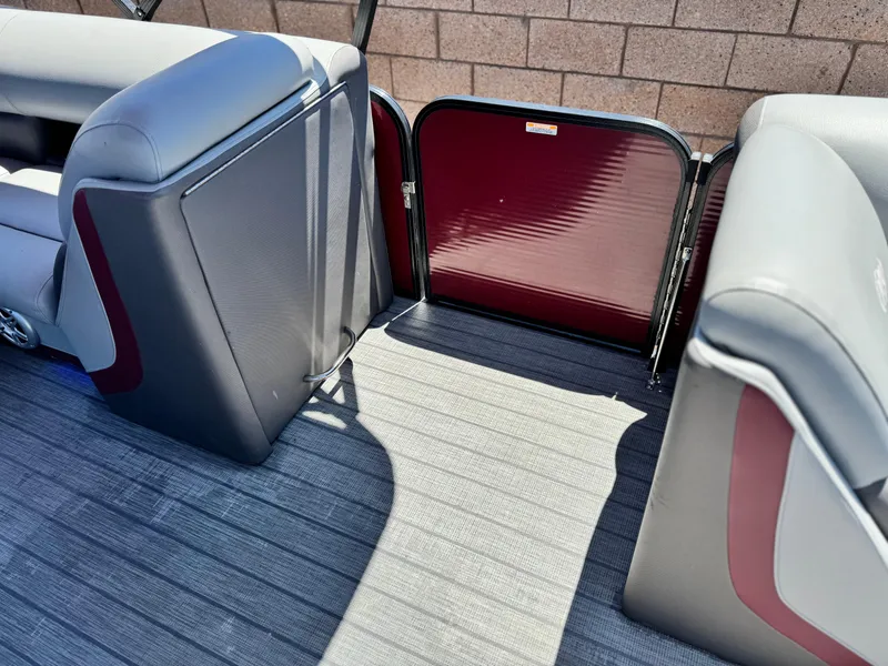 Slide: The Image of 2019 Manitou 23 Oasis boat interior with gray and maroon seating and flooring. - 14