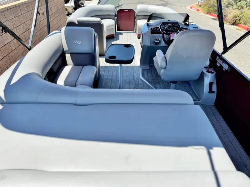 Slide: The Image of 2019 Manitou 23 Oasis pontoon boat interior with seating and steering console. - 21