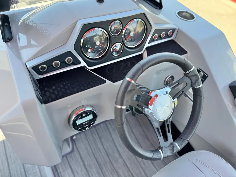 Slide: The Image of Dashboard of 2019 Manitou 23 Oasis boat with steering wheel and gauges. - 24