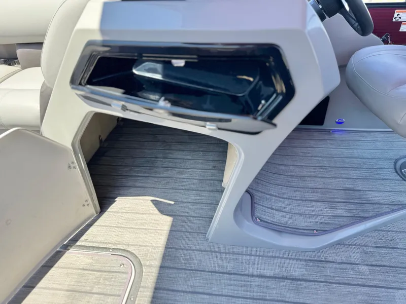 Slide: The Image of 2019 Manitou 23 Oasis interior with open storage compartment and sleek seating. - 28