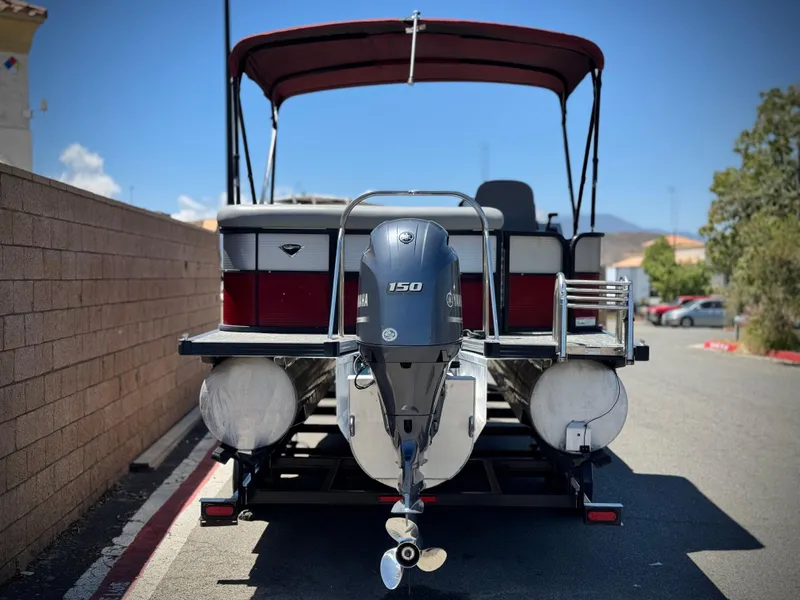 Slide: The Image of 2019 Manitou 23 Oasis pontoon boat with 150 HP engine, parked on a sunny day. - 5