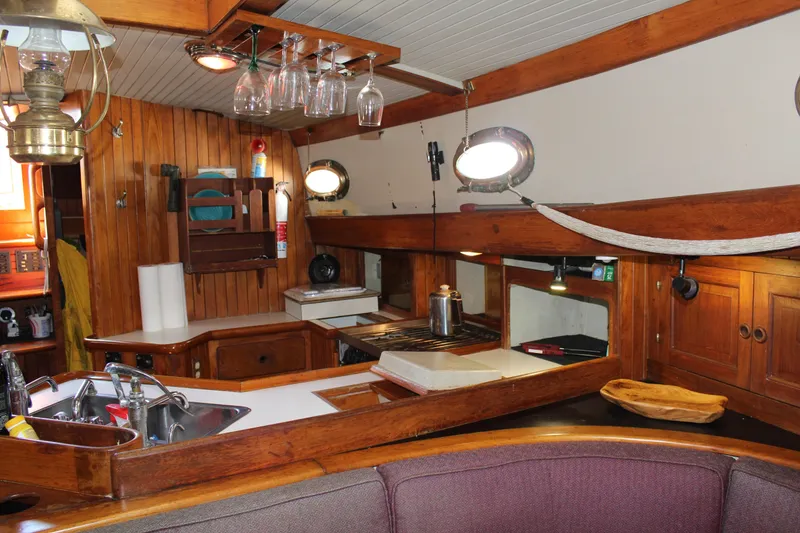 Slide: The Image of Interior of 1979 Hans Christian 38 Ketch, featuring a cozy wooden kitchen and dining area. - 10