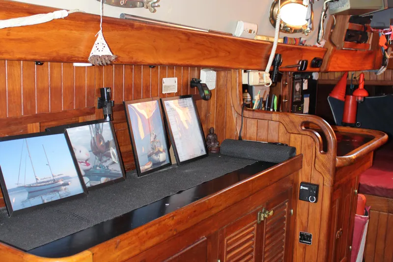 Slide: The Image of 1979 Hans Christian 38 Ketch interior with wooden cabinetry and framed nautical photos. - 13