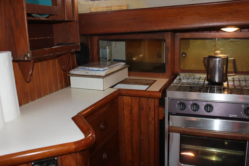 Slide: The Image of 1979 Hans Christian 38 Ketch galley with wooden cabinetry and stainless steel stove. - 17