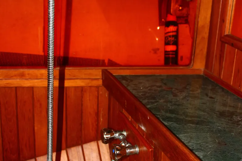 Slide: The Image of Wooden interior of 1979 Hans Christian 38 Ketch with marble countertop and red lighting. - 21