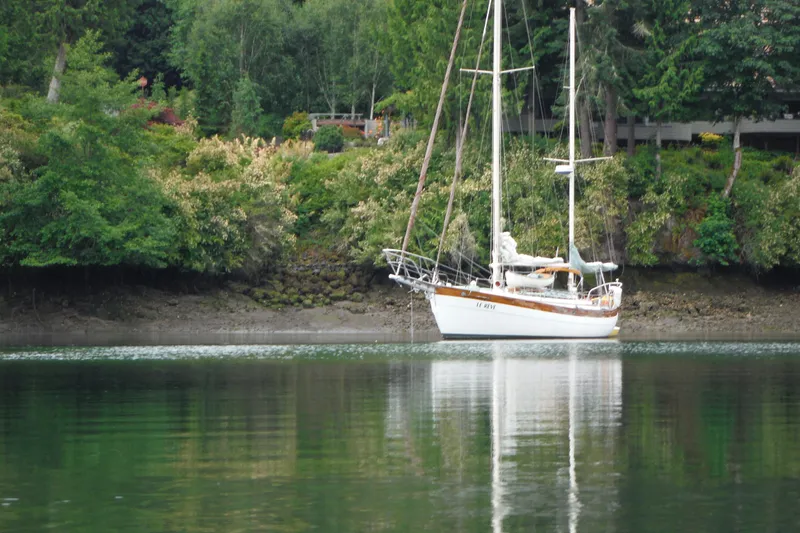 Slide: The Image of 1979 Hans Christian 38 Ketch anchored near lush, green shoreline. - 35