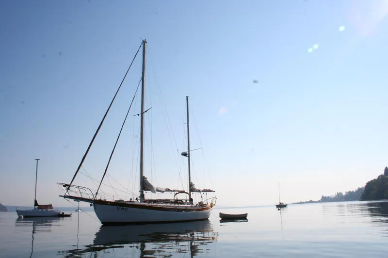 Slide: The Image of 1979 Hans Christian 38 Ketch sailboat on calm water under clear blue sky. - 36