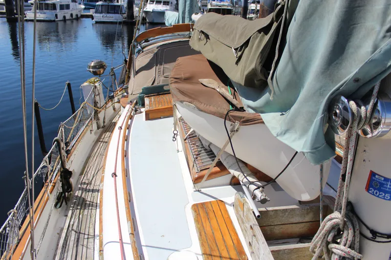 Slide: The Image of 1979 Hans Christian 38 Ketch sailboat docked at marina, featuring covered deck and rigging. - 6