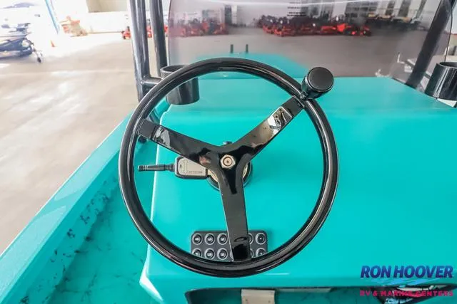 Slide: The Image of Steering wheel of a 2025 Majek 18 M2 boat, turquoise dashboard, Ron Hoover logo visible. - 16