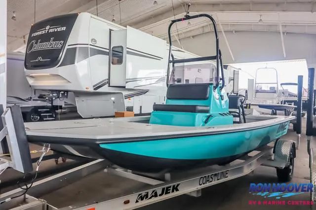 Slide: The Image of 2025 Majek 18 M2 boat on trailer in showroom, turquoise color. - 3