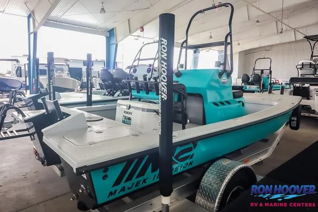 Slide: The Image of 2025 Majek 18 M2 boat in showroom, turquoise color, displayed at Ron Hoover RV & Marine Centers. - 6