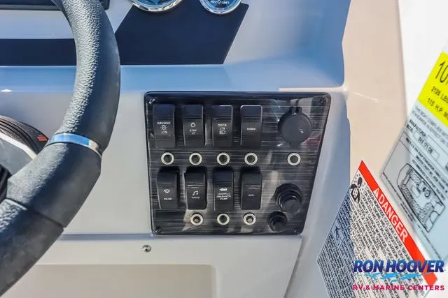 Slide: The Image of Control panel of 2025 Starcraft SVX171 boat with switches and steering wheel. - 23