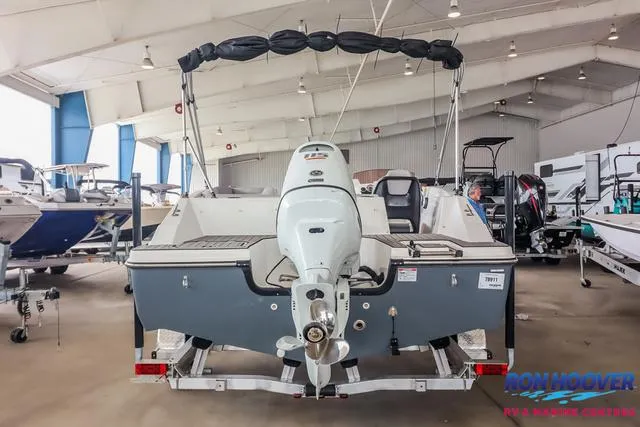 Slide: The Image of 2025 Starcraft SVX171 boat displayed in a showroom, rear view with motor and canopy. - 6