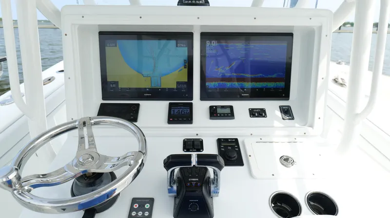 Slide: The Image of 2017 Yellowfin 36 Offshore boat dashboard with dual navigation screens and steering wheel. - 15