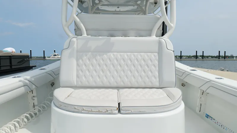 Slide: The Image of 2017 Yellowfin 36 Offshore boat with white cushioned seating, docked by the water. - 30