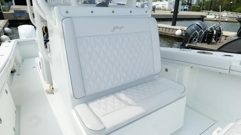 Slide: The Image of 2017 Yellowfin 36 Offshore boat with white cushioned seating at a marina. - 40