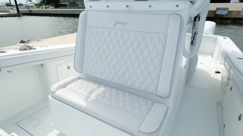 Slide: The Image of 2017 Yellowfin 36 Offshore boat with white diamond-stitched seating, docked by the water. - 42
