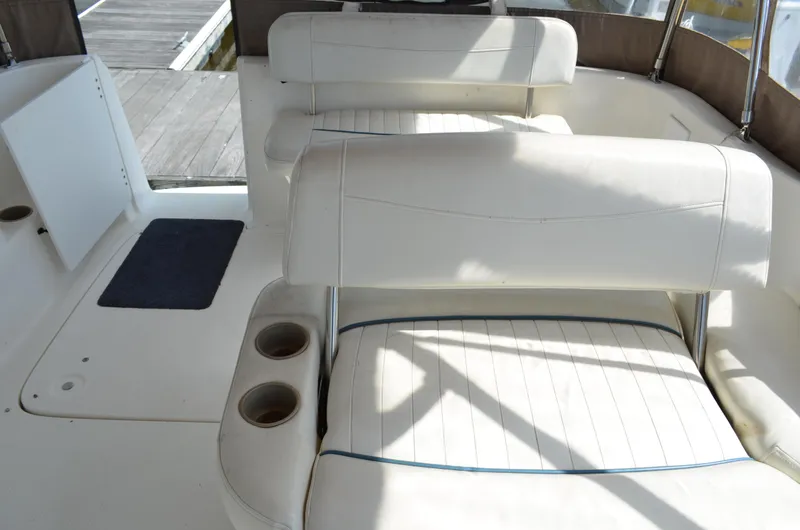 Slide: The Image of 2001 Bayliner 2655 Ciera boat interior with white seating and cup holders. - 16