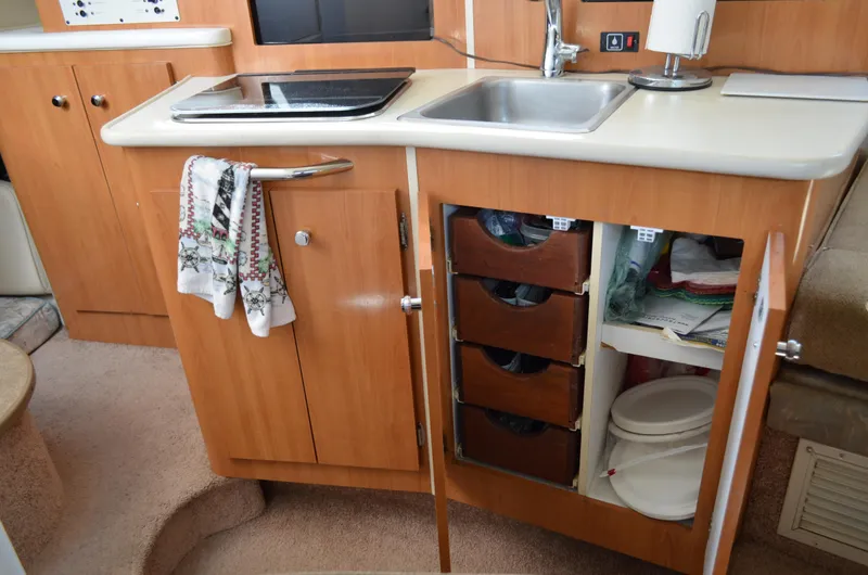 Slide: The Image of 2001 Bayliner 2655 Ciera kitchen area with sink, stove, and storage cabinets. - 31