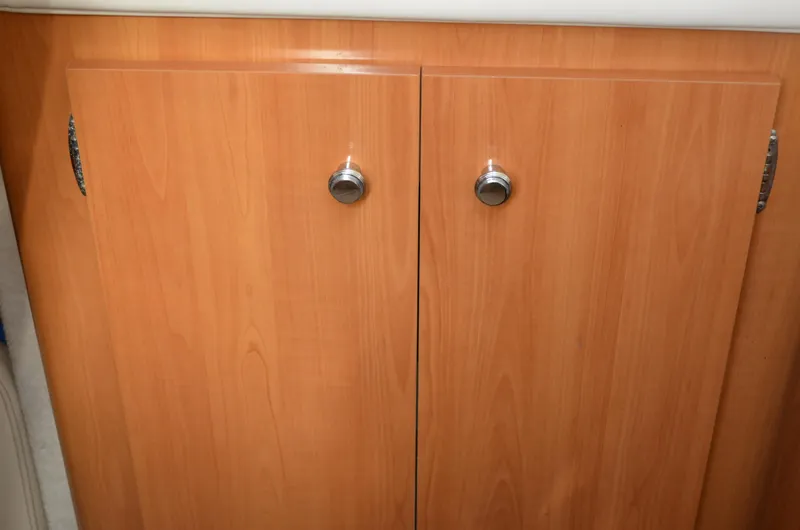 Slide: The Image of Wooden cabinet doors with metal knobs inside a 2001 Bayliner 2655 Ciera boat. - 37
