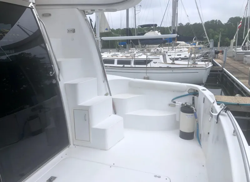 Slide: The Image of 2000 Carver 450 Voyager Pilothouse yacht docked at marina, featuring white deck and steps. - 14