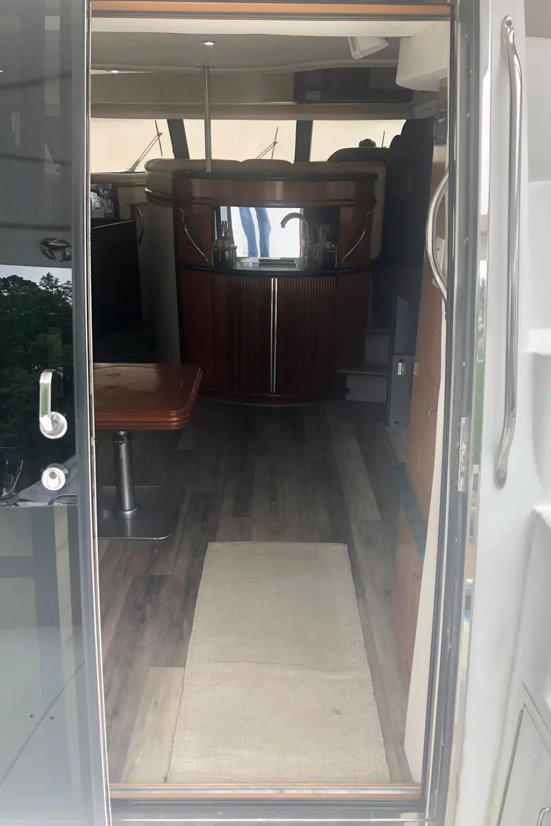 Slide: The Image of Interior view of 2000 Carver 450 Voyager Pilothouse yacht, featuring wood flooring and seating area. - 35