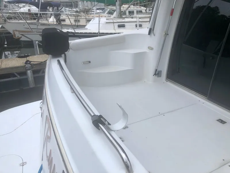 Slide: The Image of 2000 Carver 450 Voyager Pilothouse yacht deck with steps and railing in marina. - 13