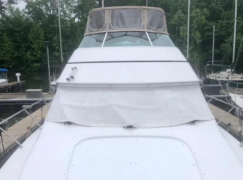 Slide: The Image of 2000 Carver 450 Voyager Pilothouse yacht docked, featuring a sleek white exterior. - 16