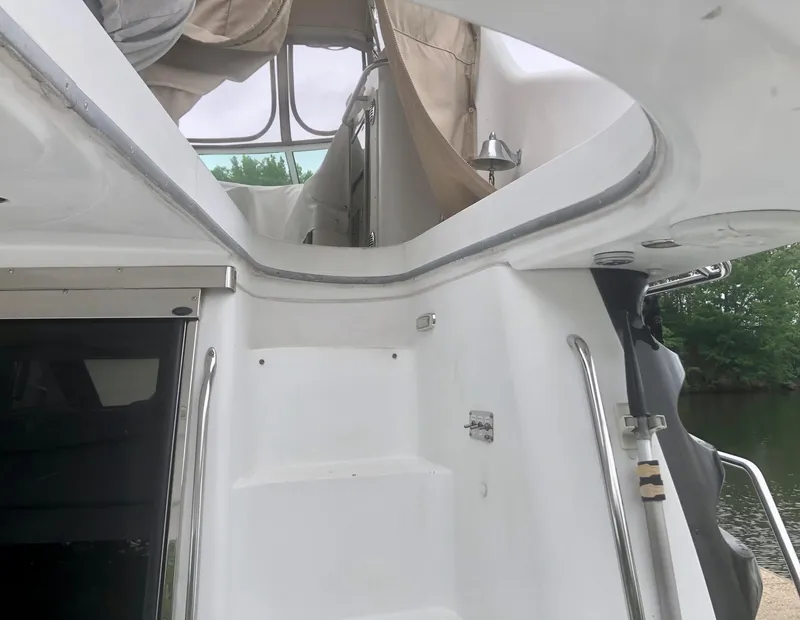 Slide: The Image of 2000 Carver 450 Voyager Pilothouse yacht with stairs and railing, featuring outdoor canopy. - 21