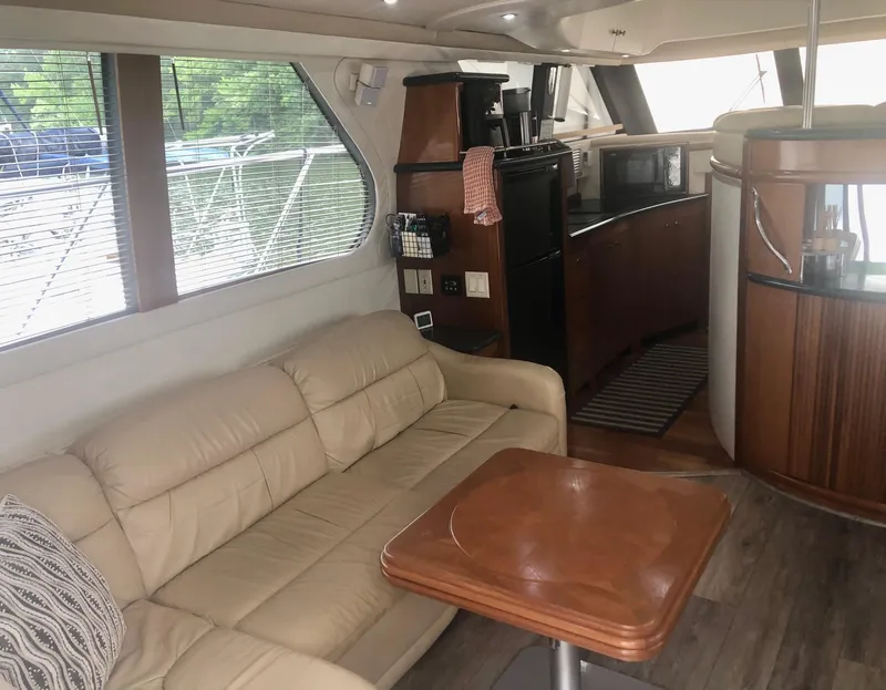 Slide: The Image of Interior of 2000 Carver 450 Voyager Pilothouse with beige sofa and wooden table. - 36