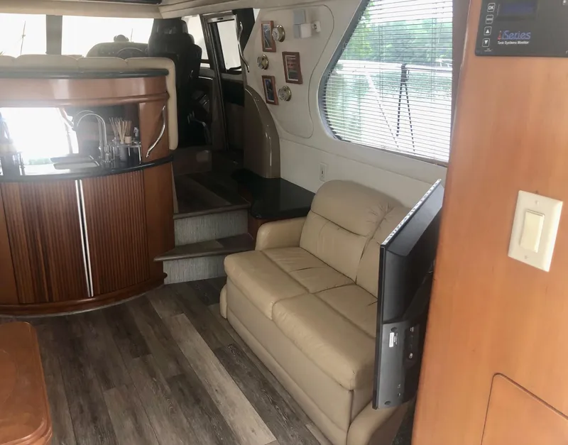 Slide: The Image of Interior of 2000 Carver 450 Voyager Pilothouse with sofa, bar, and wood flooring. - 37