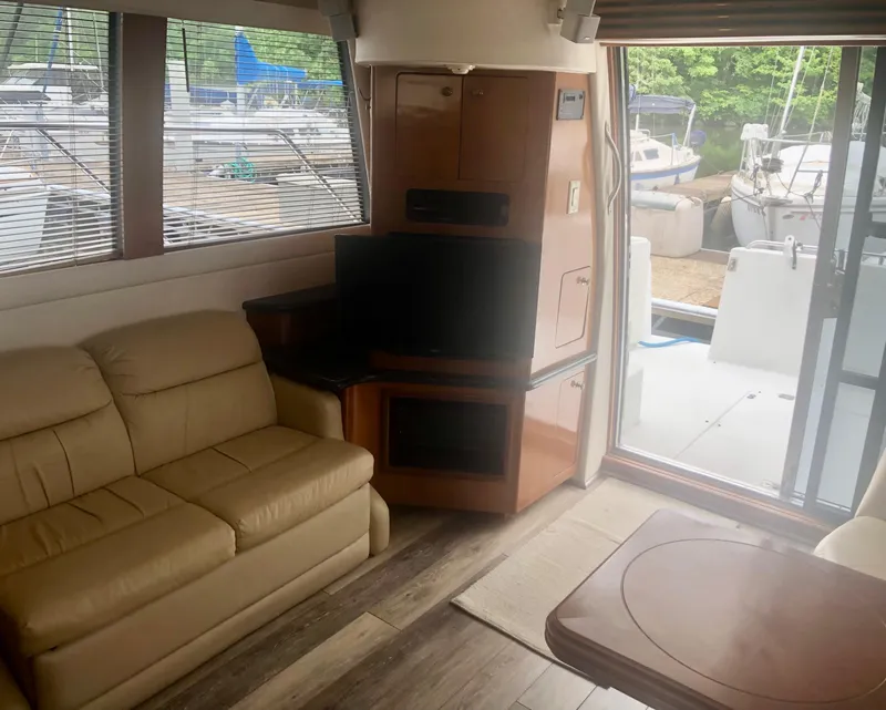 Slide: The Image of Interior of 2000 Carver 450 Voyager Pilothouse with beige sofa, TV, and large windows. - 39