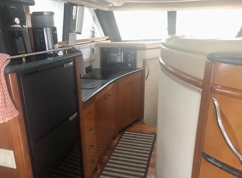 Slide: The Image of Interior of 2000 Carver 450 Voyager Pilothouse with kitchen appliances and wooden cabinetry. - 47