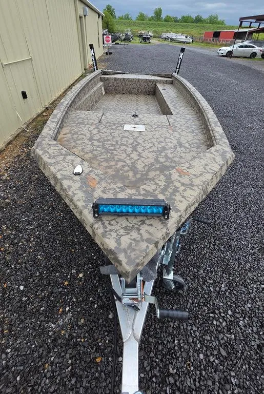 Slide: The Image of 2025 Xpress H18DB boat with camouflage design on gravel lot. - 1