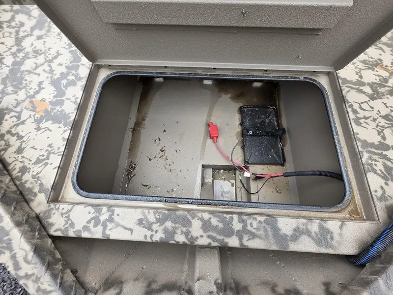Slide: The Image of Open storage compartment in 2025 Xpress H18DB boat, showing wiring and battery setup. - 10
