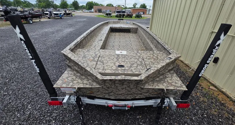 Slide: The Image of 2025 Xpress H18DB boat on trailer, camo design, parked outdoors. - 11