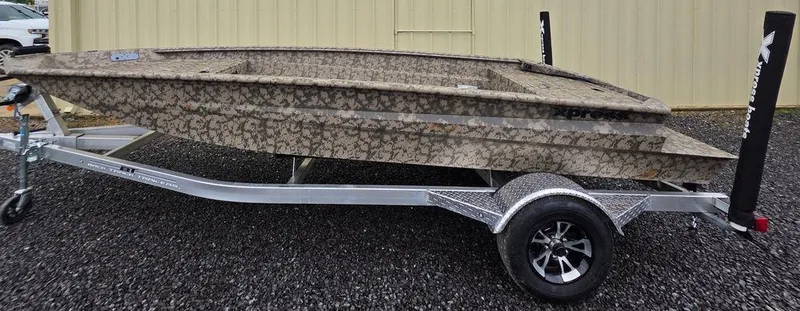 Slide: The Image of 2025 Xpress H18DB boat on trailer, camouflage design, parked on gravel. - 17