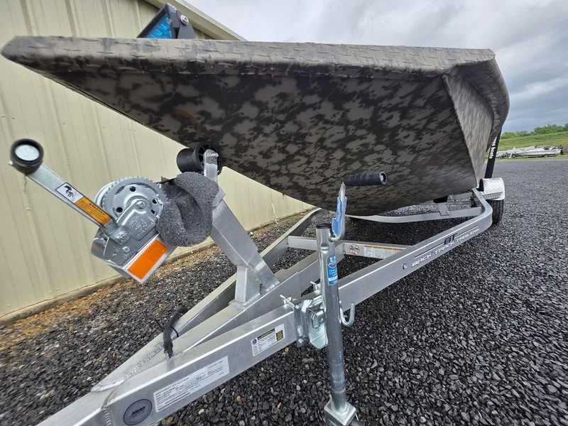 Slide: The Image of 2025 Xpress H18DB boat on trailer, parked on gravel near a building. - 20