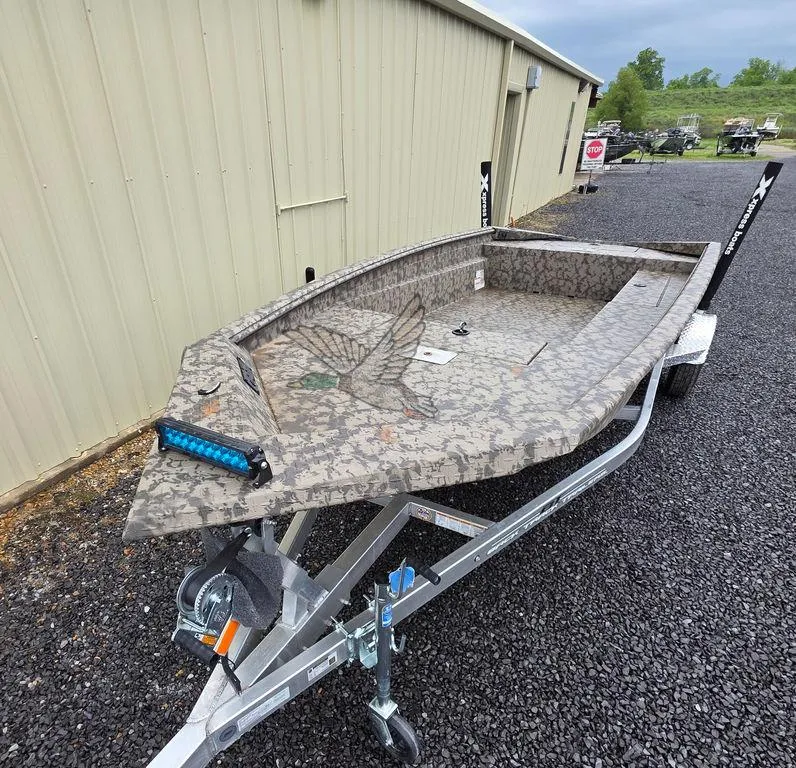 Slide: The Image of 2025 Xpress H18DB boat on trailer, camouflage design, parked outdoors. - 22