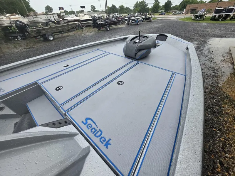 Slide: The Image of 2025 Xpress H20 Bass boat with SeaDek flooring, parked outdoors on a rainy day. - 10