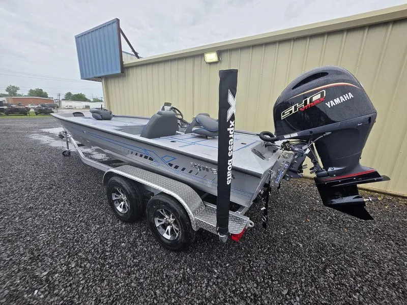 Slide: The Image of 2025 Xpress H20 Bass boat with Yamaha engine on a trailer, parked outdoors. - 4