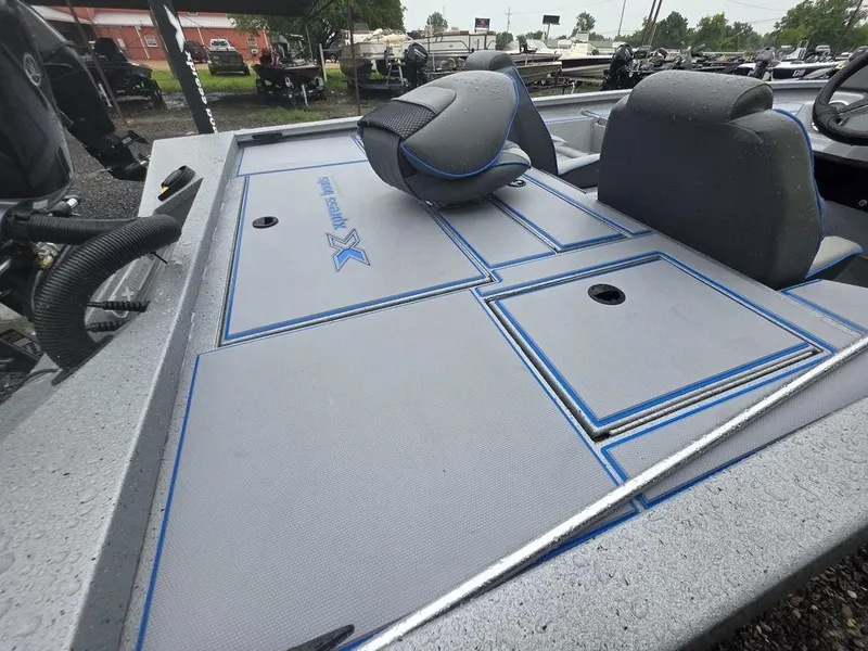 Slide: The Image of 2025 Xpress H20 Bass boat interior with gray and blue seating and storage compartments. - 6
