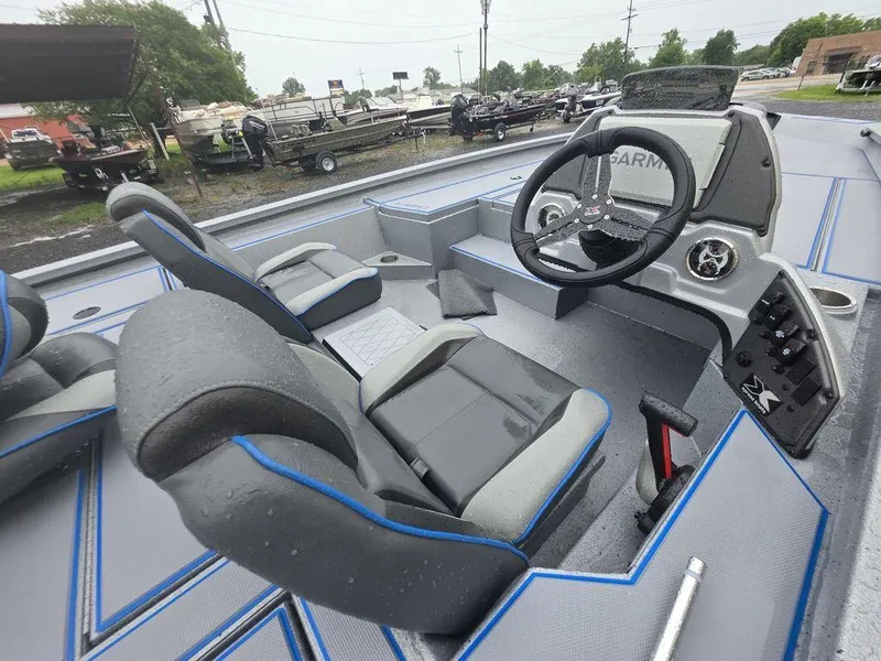 Slide: The Image of 2025 Xpress H20 Bass boat interior with steering wheel and seating, featuring modern design. - 7