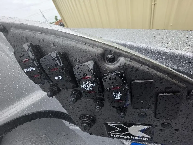 Slide: The Image of Control panel of 2025 Xpress H20 Bass boat with switches and raindrops. - 9