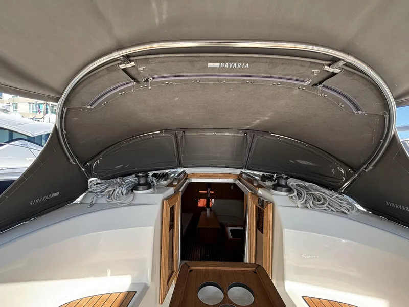 Slide: The Image of Bavaria Cruiser 34 yacht cockpit with open hatch, ropes, and wooden details, 2020 model. - 13