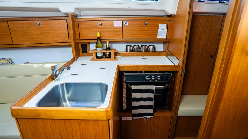 Slide: The Image of 2020 Bavaria Cruiser 34 yacht kitchen with wooden cabinetry and modern appliances. - 30