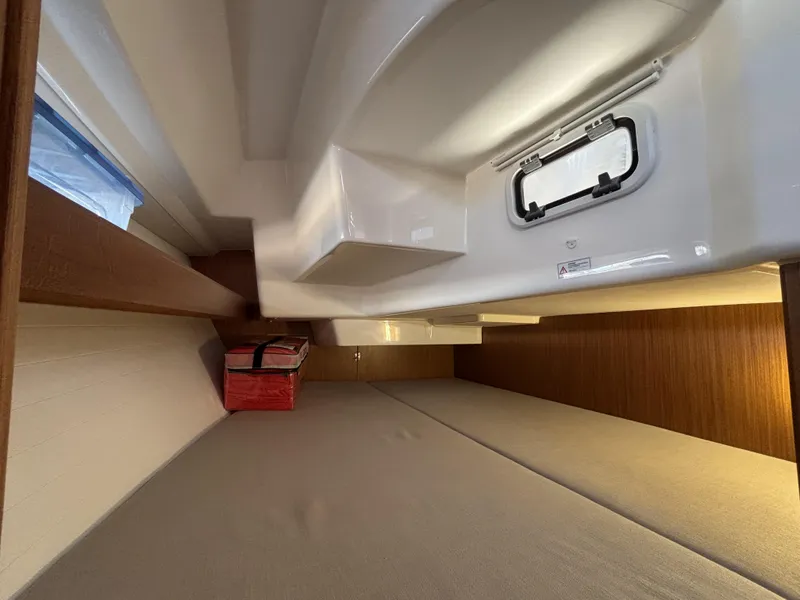 Slide: The Image of Interior cabin of 2020 Bavaria Cruiser 34 yacht with wooden accents and a small window. - 34