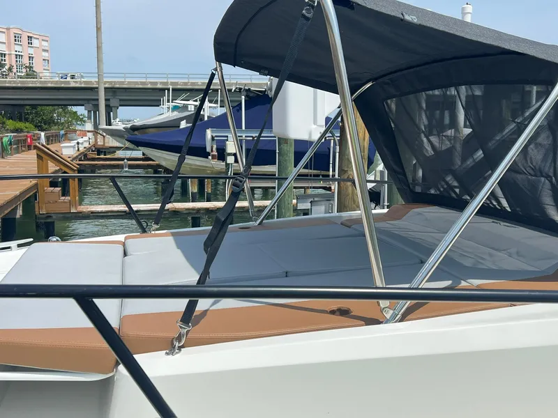 Slide: The Image of 2024 Beneteau 29' Flyer 9 SUNdeck moored at a marina, featuring a sleek design and sunshade. - 13